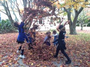 Kids jumping in leaves